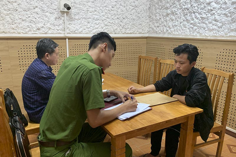  Đối tượng Lê Quang Minh Trung (áo đen) đầu thú sau gần 3 năm lẩn trốn.