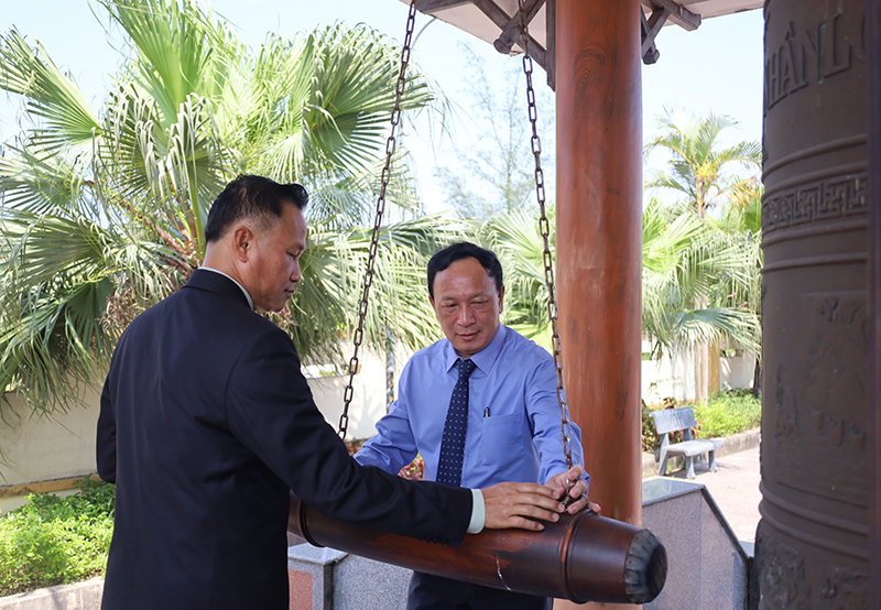 Đồng chí Trần Hải Châu, Phó Bí thư Thường trực Tỉnh ủy, Chủ tịch HĐND tỉnh và đồng chí Kẹo U Đon Bụt Xing Khỏn, Phó Tỉnh trưởng tỉnh Khăm Muồn thực hiện nghi lễ thỉnh chuông truyền thống.