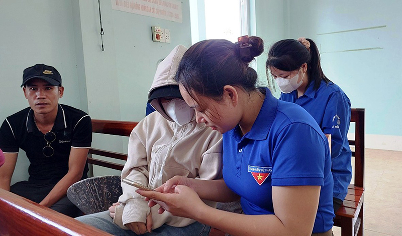 Các đoàn viên, thanh niên hướng dẫn người dân cài đặt sổ sức khoẻ điện tử và Ba Đồn Smart.