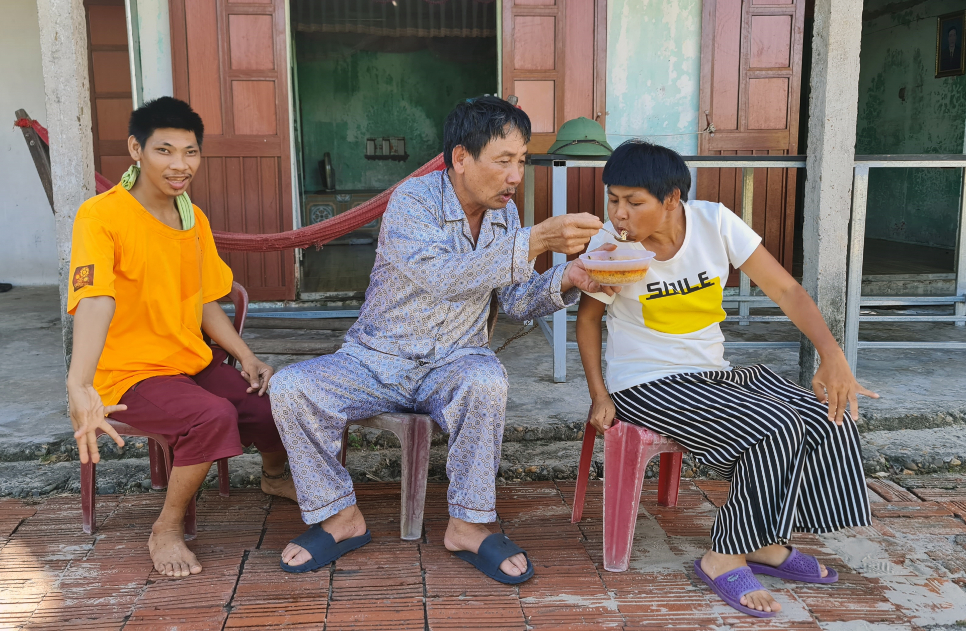 Ông Trương Tâm phải đút từng muỗng thức ăn cho những đứa con ngờ nghệch.