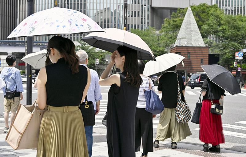  Người dân đi bộ ở quận Ginza của Tokyo hôm 18/6. Ảnh: Kyodo