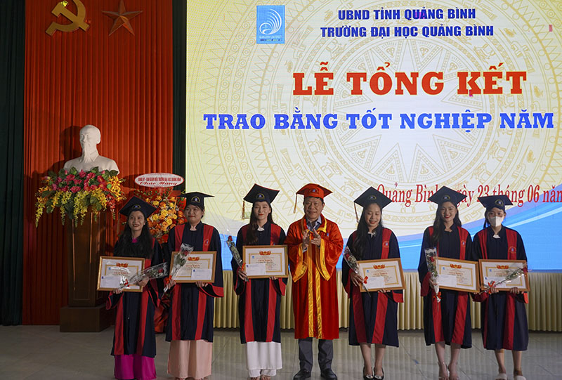 Đại diện lãnh đạo Trường ĐHQB tặng thưởng cho SV thủ khoa toàn khóa.