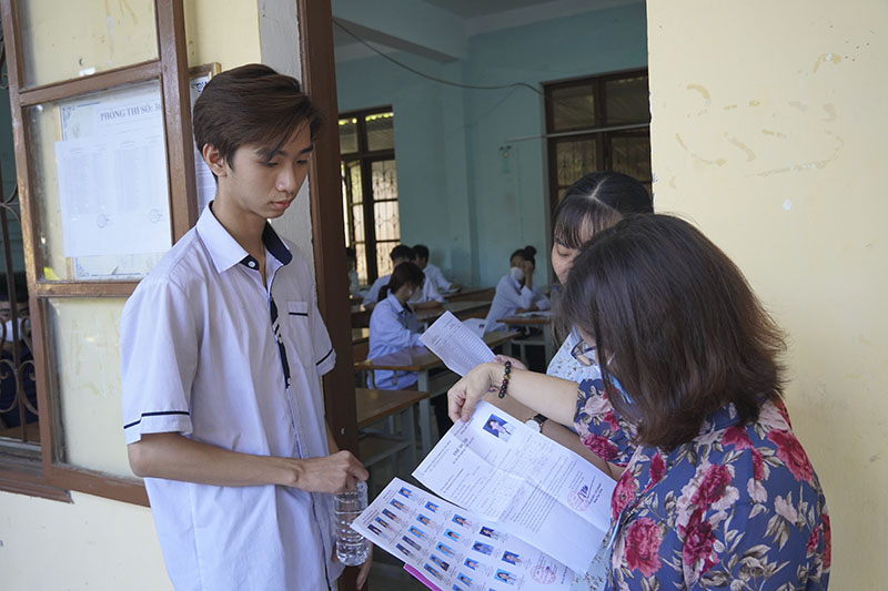Cán bộ coi thi rà soát thông tin cá nhân của thí sinh trước khi vào phòng thi.