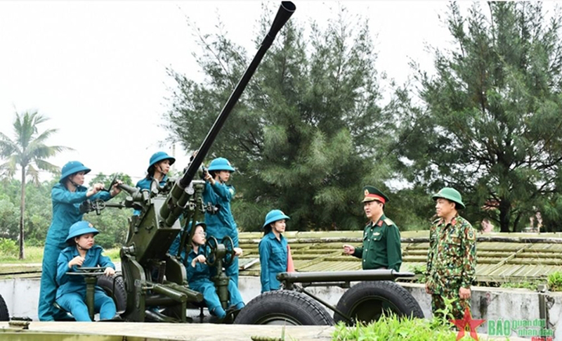 Thượng tá Trần Hiếu Minh (thứ hai từ bên phải sang) động viên các pháo thủ Đại đội nữ dân quân thường trực pháo phòng không 37mm thành phố Đồng Hới, tỉnh Quảng Bình. 