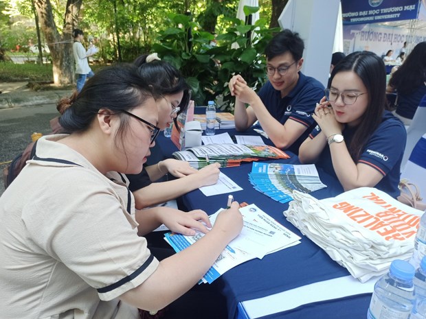 Thí sinh gặp gỡ đại diện các trường đại học để tư vấn xét tuyển. (Ảnh: PV/Vietnam+)