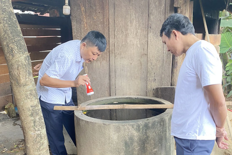 Cán bộ Trung tâm Y tế huyện hướng dẫn người dân tìm và diệt loăng quăng phòng bệnh SXH.