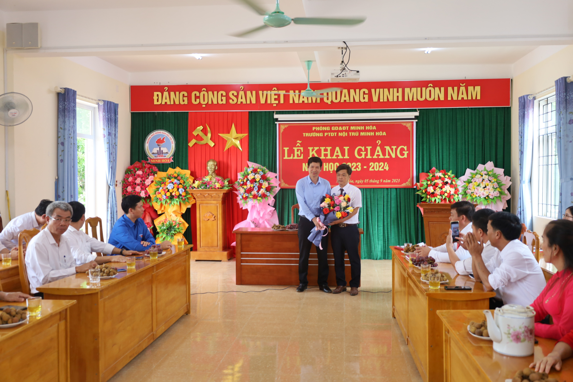 Đồng chí Hồ An Phong, Tỉnh ủy viên, Phó Chủ tịch UBND tỉnh tặng hoa chúc mừng Trường Phổ thông Dân tộc nội trú huyện Minh Hóa nhân ngày khai giảng năm học mới.