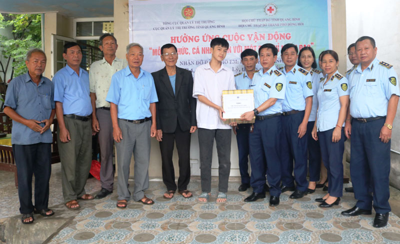 Lãnh đạo Cục QLTT trao tặng đồ dùng học tập cho em Phan Quốc Anh trong năm học mới.