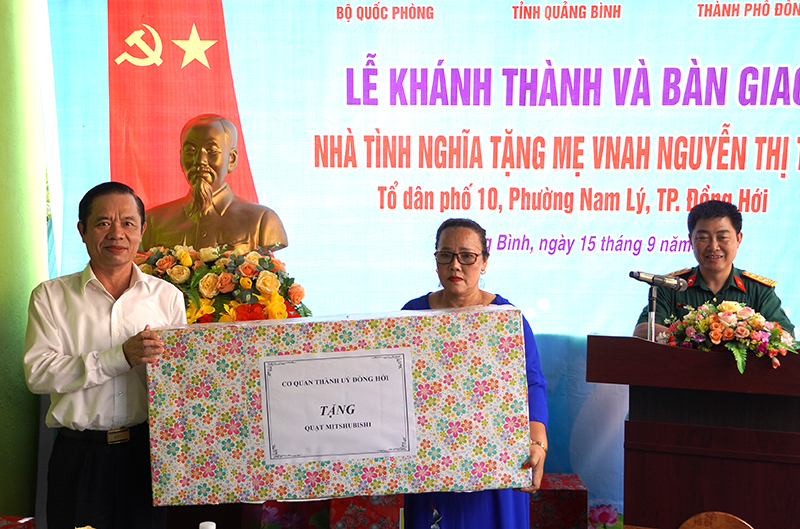 Đại diện Thường trực Thành ủy Đồng Hới trao quà tặng Mẹ VNAH Nguyễn Thị Trữ cho người thân của mẹ.