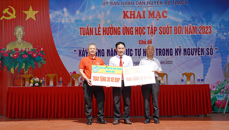 Lãnh đạo Phòng Giáo dục và Đào tạo huyện Bố Trạch tiếp nhận biển tượng trưng tặng xe đạp cho học sinh của Câu lạc bộ xe đạp xanh Hoàn Lão và Hội nạn nhân chất độc da cam/dioxin Bố Trạch.