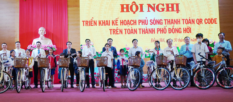 Đại diện các ngân hàng trao xe đạp cho học sinh có hoàn cảnh khó khăn. 