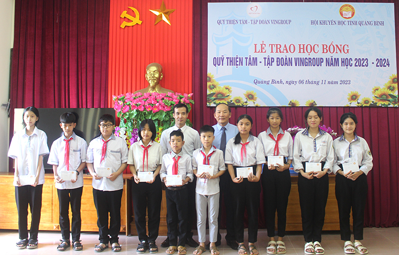 Đại diện lãnh đạo Hội Khuyến học tỉnh và nhà tài trợ trao học bổng cho các học sinh huyện Bố Trạch.