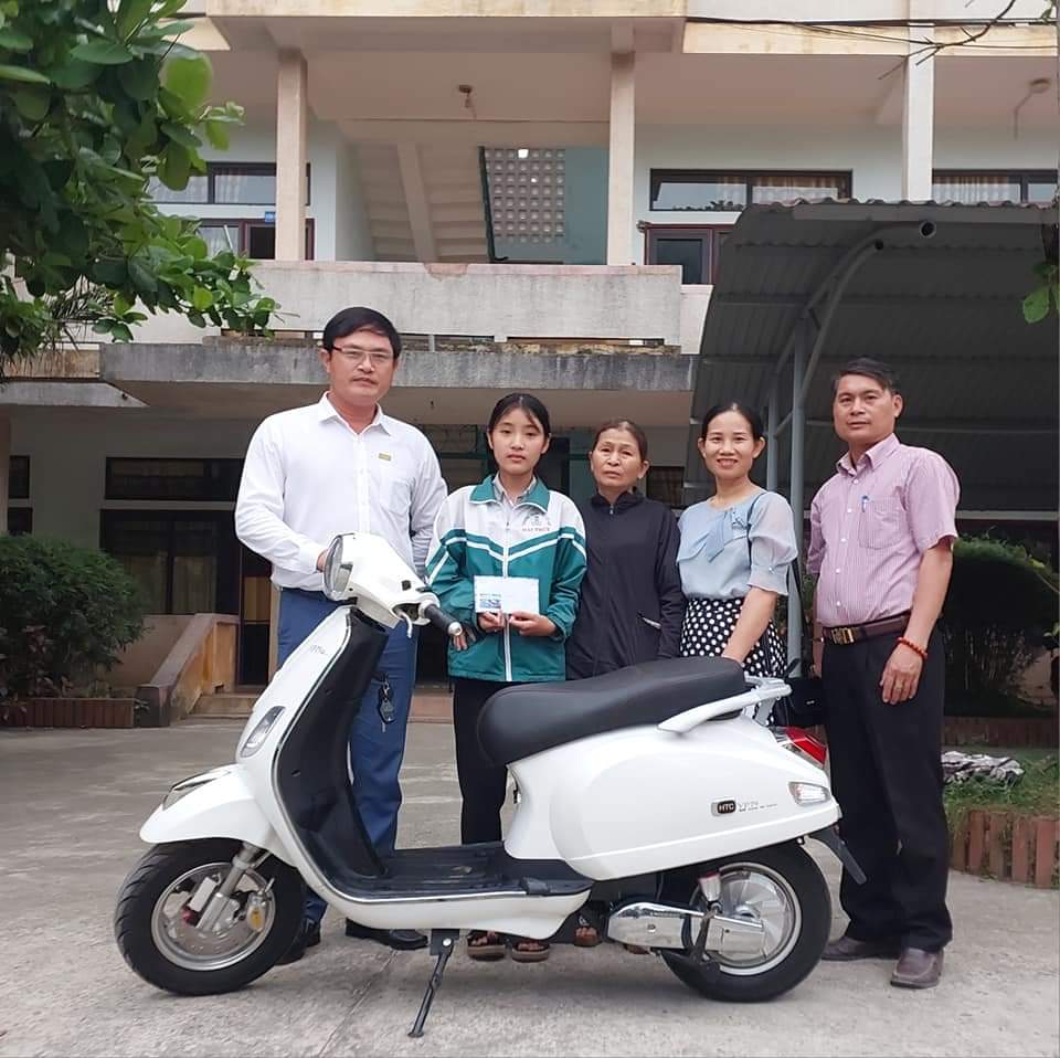 Thầy giáo Đỗ Đức Thuần (bên trái ảnh) trao phương tiện giúp học sinh nghèo có điều kiện đến trường.