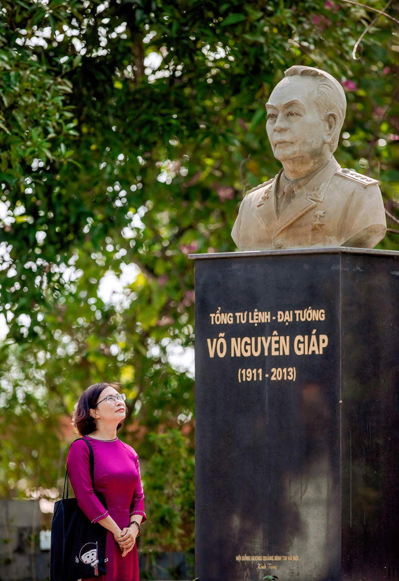Cô giáo Nguyễn Thị Thanh Hương bên bức tượng Đại tướng Võ Nguyên Giáp trong khuôn viên nhà trường.