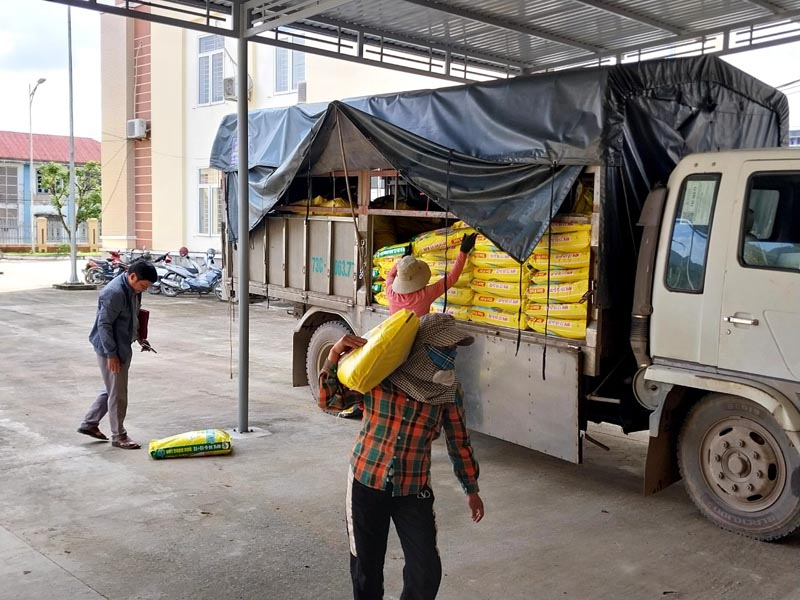Các hộ dân ở thị trấn Quy Đạt nhận giống và phân bón. 