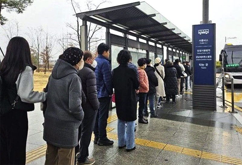 Người dân Hàn Quốc xếp hàng chờ xe chở tới Trung tâm y tế Samsung ở thủ đô Seoul.