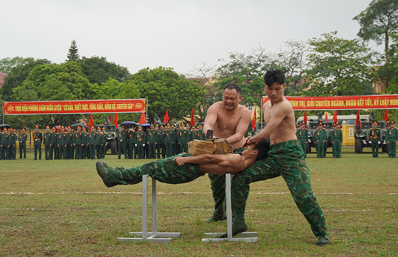 : Chiến sỹ BĐBP tỉnh vận khí công nằm trên 2 thanh sắt, để đồng đội đập vỡ tảng đá lớn trên bụng.