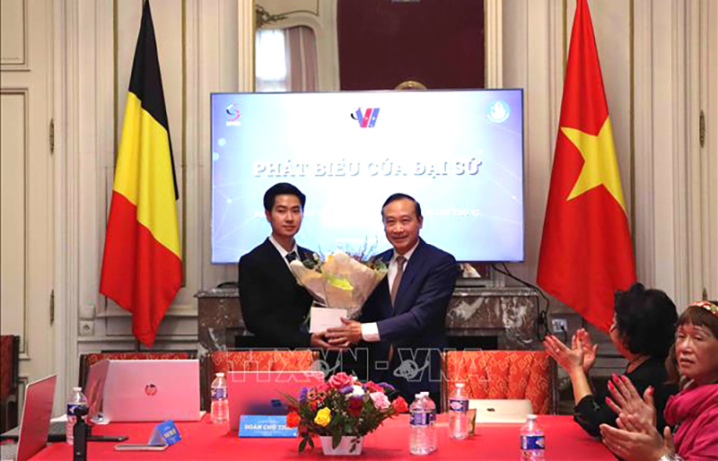 Đại sứ Việt Nam tại Vương quốc Bỉ Nguyễn Văn Thảo tặng hoa chúc mừng Chủ tịch Hội sinh viên Việt Nam tại Bỉ khóa V Nguyễn Tuấn Nghĩa. Ảnh: Hương Giang/PV TTXVN tại Bỉ