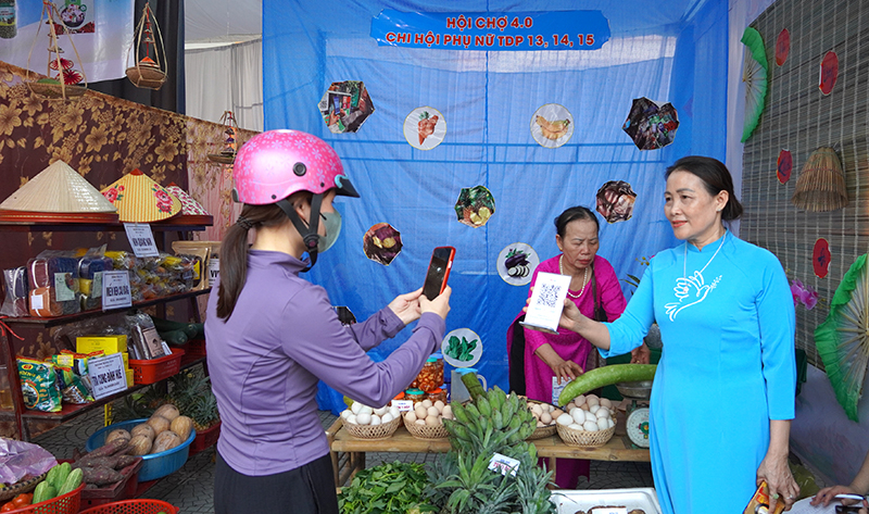Người dân mua hàng và quét mã QR tại hội chợ.