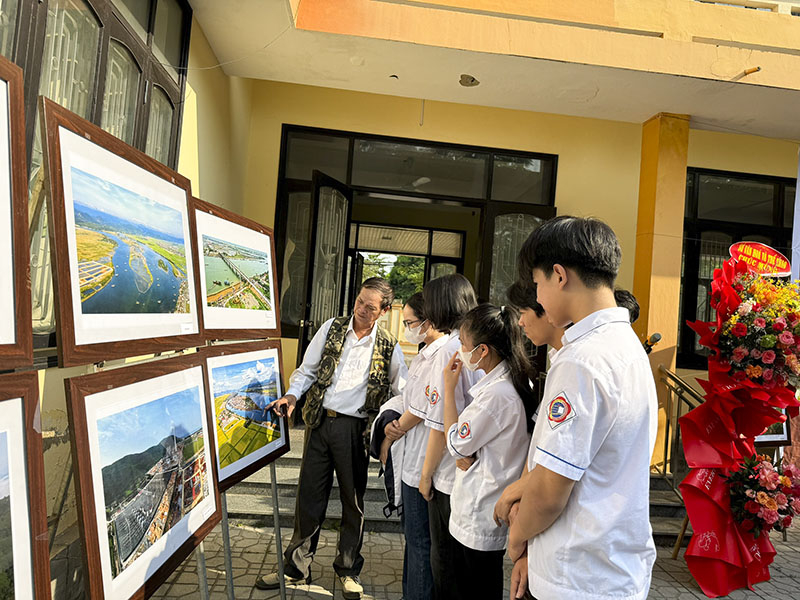 Tác giả Bách Chiến cùng các em học sinh tại triển lãm
