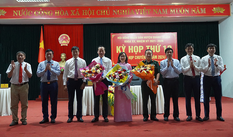 Đồng chí Phó Chủ tịch Thường trực HĐND tỉnh Nguyễn Công Huấn và lãnh đạo huyện Quảng Trạch tặng hoa chúc mừng các đồng chí Nguyễn Xuân Đạt, Vũ Thị Mai và Lê Mậu Thịnh.