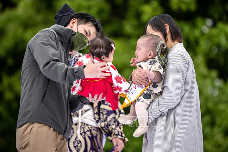 Cha mẹ cho các con tham gia một trò chơi ở Tokyo, Nhật Bản. Ảnh: AFP/TTXVN