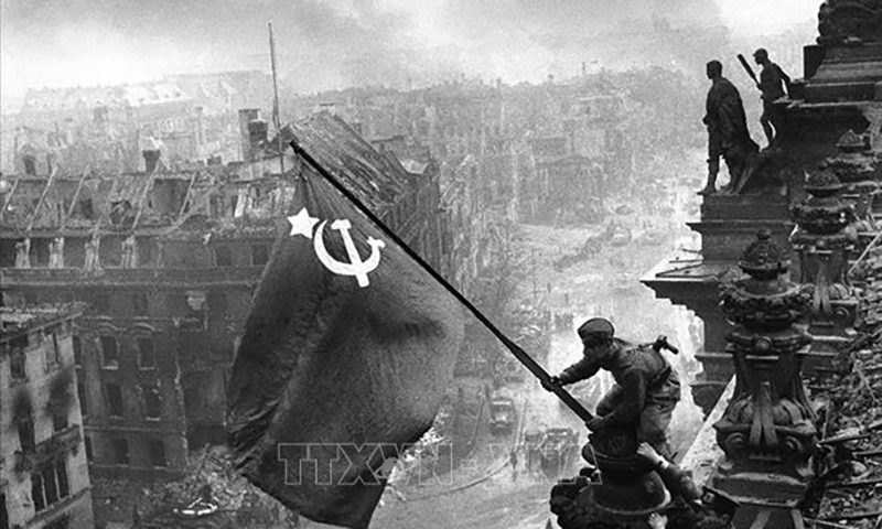 Chiến sĩ Hồng quân thuộc Phương diện quân Byelorussia 1 cắm lá cờ chiến thắng lên nóc Nhà Quốc hội Đức, chiều 30/4/1945. Ảnh: Tư liệu quốc tế/TTXVN phát
