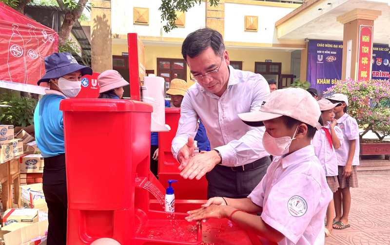 Chủ tịch Hội Thầy thuốc trẻ Việt Nam Ts.Bs Hà Anh Đức hướng dẫn rửa tay bằng xà phòng cho học sinh tiểu học.