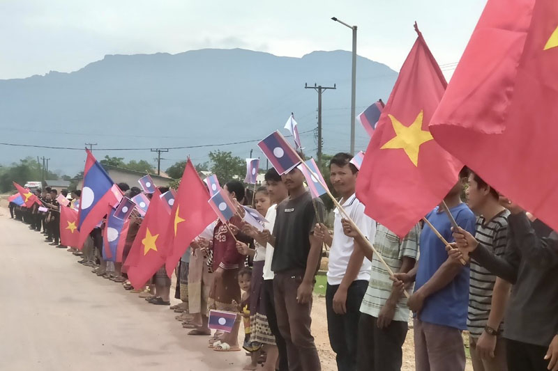 Nhân dân nước bạn Lào tiễn vẫy chào tiễn đoàn xe chở hải cốt liệt sỹ về Việt Nam.