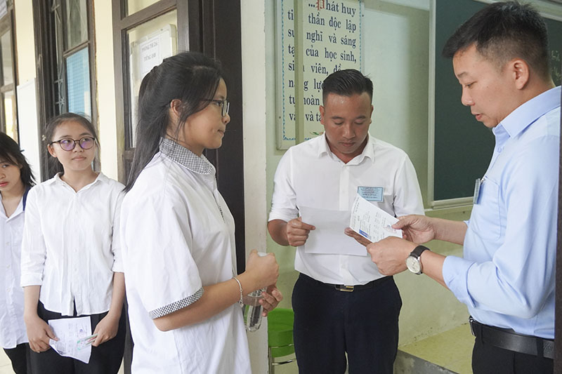 Cán bộ coi thi kiểm tra thông tin cá nhân thí sinh trước khi vào phòng thi