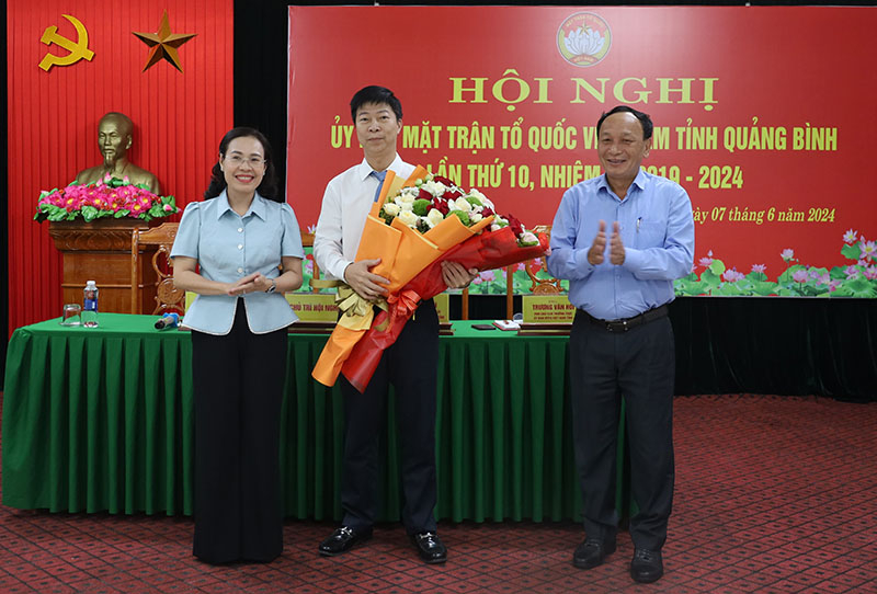Đồng chí Phó Bí thư Thường trực Tỉnh ủy Trần Hải Châu và đồng chí Chủ tịch Ủy ban MTTQVN tỉnh Phạm Thị Hân tặng hoa chúc mừng đồng chí Lê Công Cường.