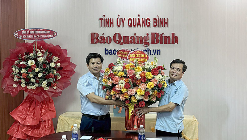 Đồng chí Ủy viên Ban Thường vụ, Trưởng ban Tổ chức Tỉnh ủy Trần Vũ Khiêm tặng hoa chúc mừng Báo Quảng Bình