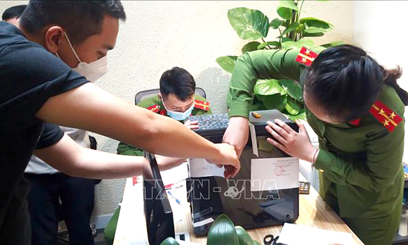 Lực lượng chức năng khám xét và niêm phong, thu giữ tài liệu tại trụ sở FLC. Ảnh tư liệu: Phạm Kiên/TTXVN