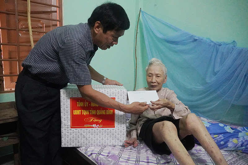 Đồng chí Phó Chủ tịch Thường trực HĐND tỉnh Nguyễn Công Huấn tặng quà cho bà Trần Thị Diệu.