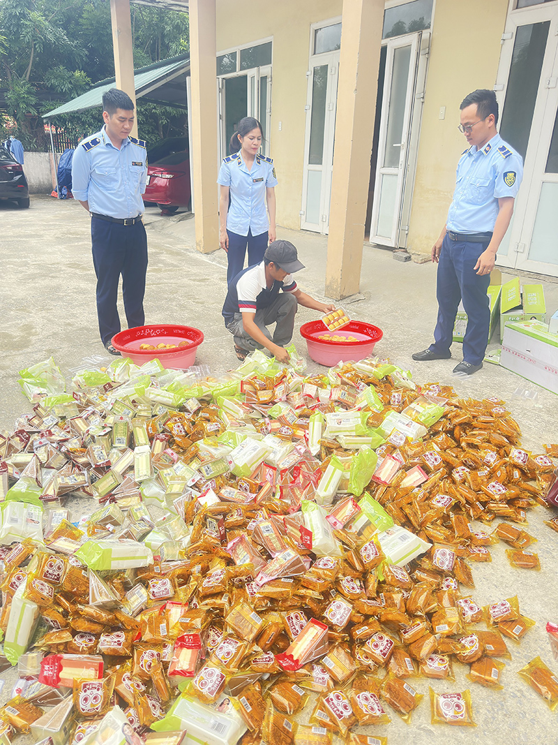 Đối tượng thực hiện tiêu hủy tang vật vi phạm dưới sự giám sát của lực lượng QLTT.