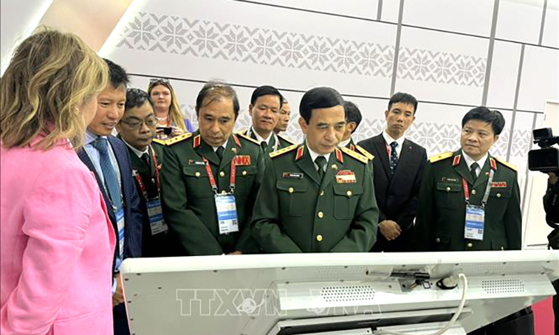 Bộ trưởng Bộ Quốc phòng, Đại tướng Phan Văn Giang và các thành viên trong đoàn tham quan các gian hàng tại ARMY-2024. Ảnh: Quang Vinh/PV TTXVN tại Nga