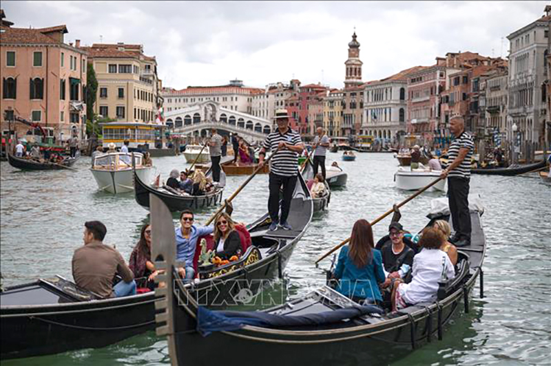Khách du lịch đi thuyền gondola tại Venice, Italy. Ảnh minh hoạ: AFP/TTXVN