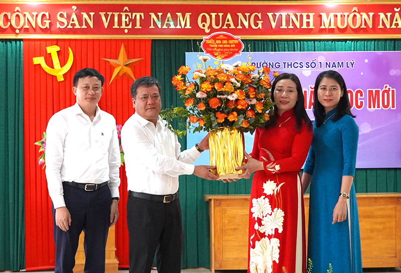 Đồng chí Bí thư Thành ủy Đồng Hới Trần Phong tặng hoa và quà chúc mừng cán bộ, giáo viên, nhân viên Trường THCS số 1 Nam Lý. 