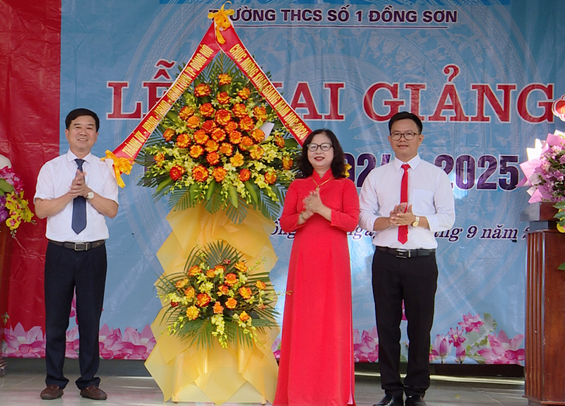 Đồng chí Phó Bí thư Thường trực Thành uỷ Đồng Hới Nguyễn Hữu Phước tặng hoa chúc mừng Trường THCS số 1 Đồng Sơn.