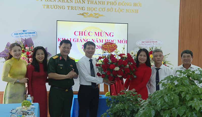 Đồng chí Chủ tịch UBND TP. Đồng Hới Hoàng Ngọc Đan và các đại biểu tặng hoa chúc mừng Trường THCS Lộc Ninh.
