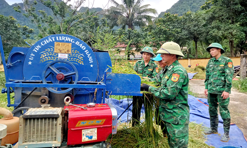 Cán bộ, chiến sỹ Đồn Biên phòng Cà Xèng giúp đồng bào Rục xã Thượng Hóa (Minh Hóa) tuốt lúa.
