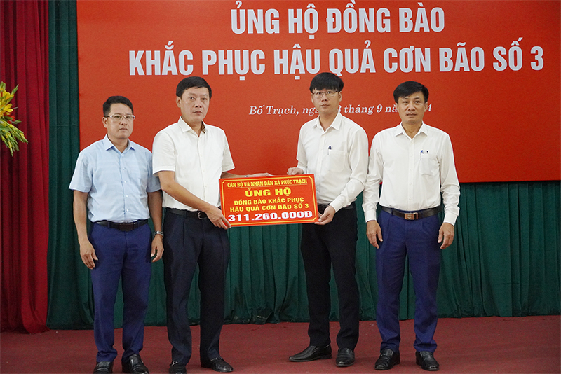 Đại diện lãnh đạo huyện Bố Trạch tiếp nhận tiền ủng hộ của các tổ chức, doanh nghiệp trên địa bàn huyện.