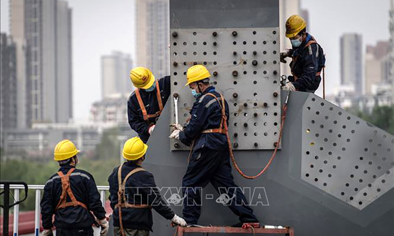 Công nhân làm việc tại công trường xây dựng ở Hồ Bắc, Trung Quốc. Ảnh: AFP/TTXVN