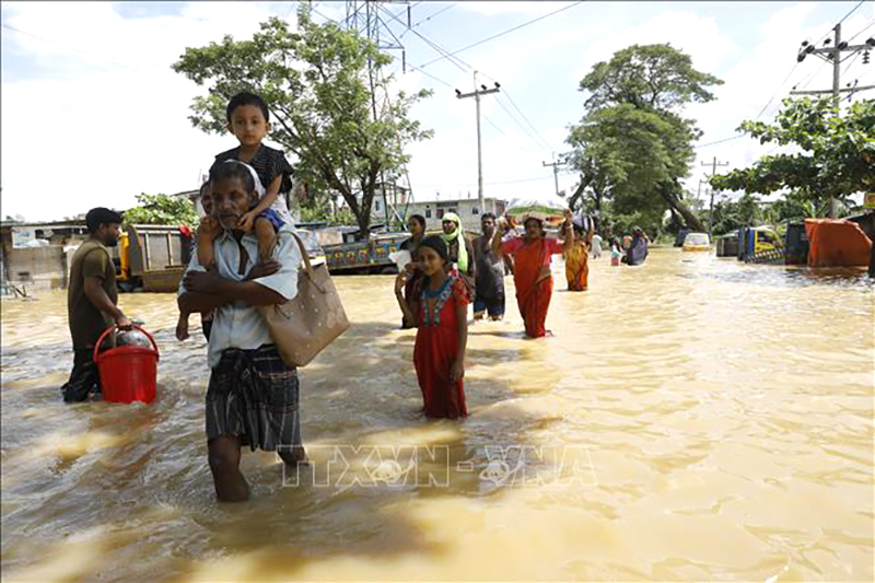 Người dân sơ tán khỏi vùng ngập lụt tại Feni, Bangladesh, ngày 24/8/2024. Ảnh: THX/TTXVN