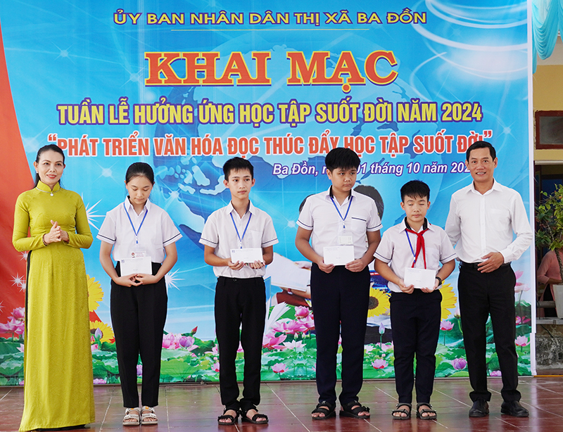 Tặng quà cho hóc sinh có thành tích học tập xuất sắc.