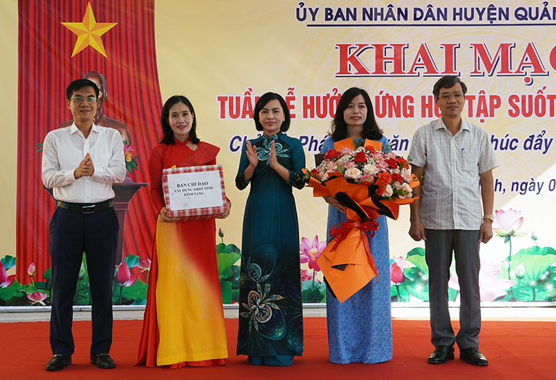 Đại diện Ban Chỉ đạo xây dựng xã hội học tập tỉnh tặng hoa và quà cho Trường THCS Duy Ninh.