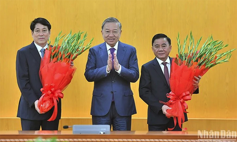 Đồng chí Tổng Bí thư Tô Lâm tặng hoa chúc mừng đồng chí Lương Cường và đồng chí Trần Cẩm Tú. (Ảnh: ĐĂNG KHOA)