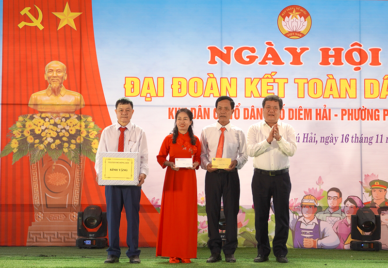 Đồng chí Bí thư Thành ủy Đồng Hới Trần Phong trao quà chúc mừng bà con tổ dân phố Diêm Hải.