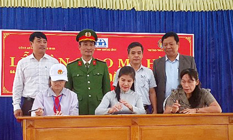 Đại diện Trường THCS thị trấn Quán Hàu, phụ huynh và học sinh ký cam kết chấp hành quy định của pháp luật về ATGT.
