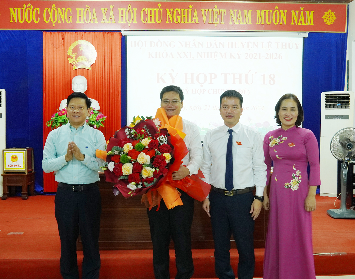Đồng chí Lê Vĩnh Thế, Tỉnh ủy viên, Phó Chủ tịch HĐND tỉnh và đại diện lãnh đạo huyện Lệ Thủy tặng hoa chúc mừng tân Chủ tịch UBND huyện Lệ Thủy Nguyễn Đình Hoà.